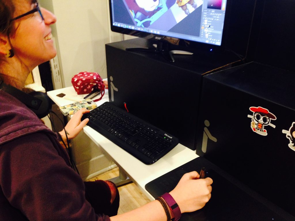 Mari sitting at her computer, illustrating game art